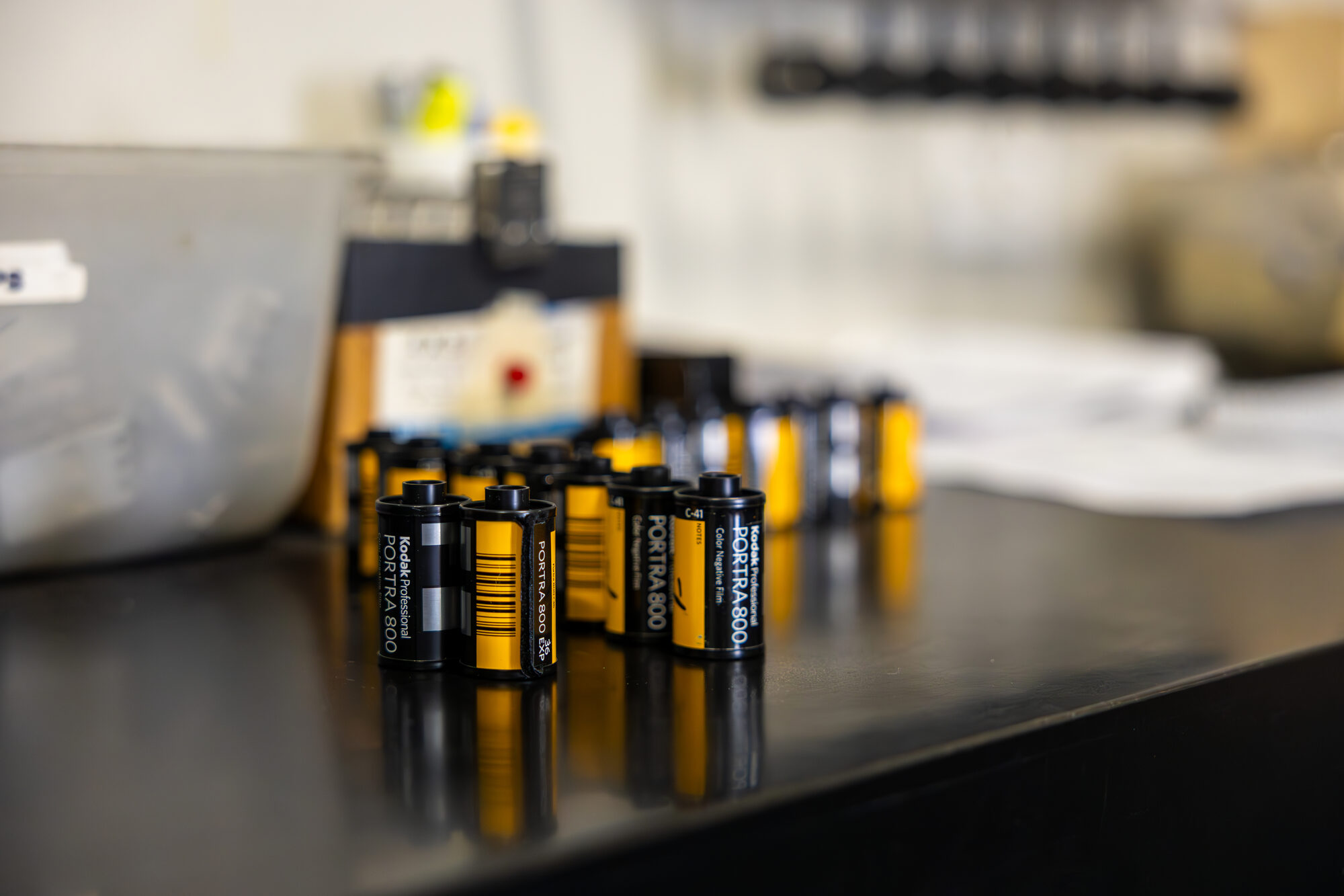 Rolls of 35mm Kodak Portra 800 color negative film on a lab counter at The Icon